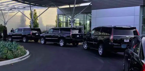 Fleet of black SUVs at a corporate arrival entrance